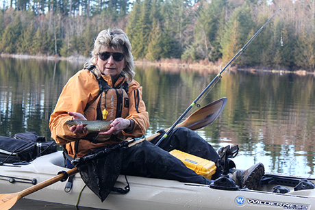Photo of kayak fishing guide Howard Zatwarnitski sitting on his kayak with a fresh-caught fish in his hands