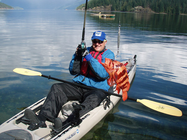 Photo of a kayak ocean kayak fishing tour participant holding up his catch